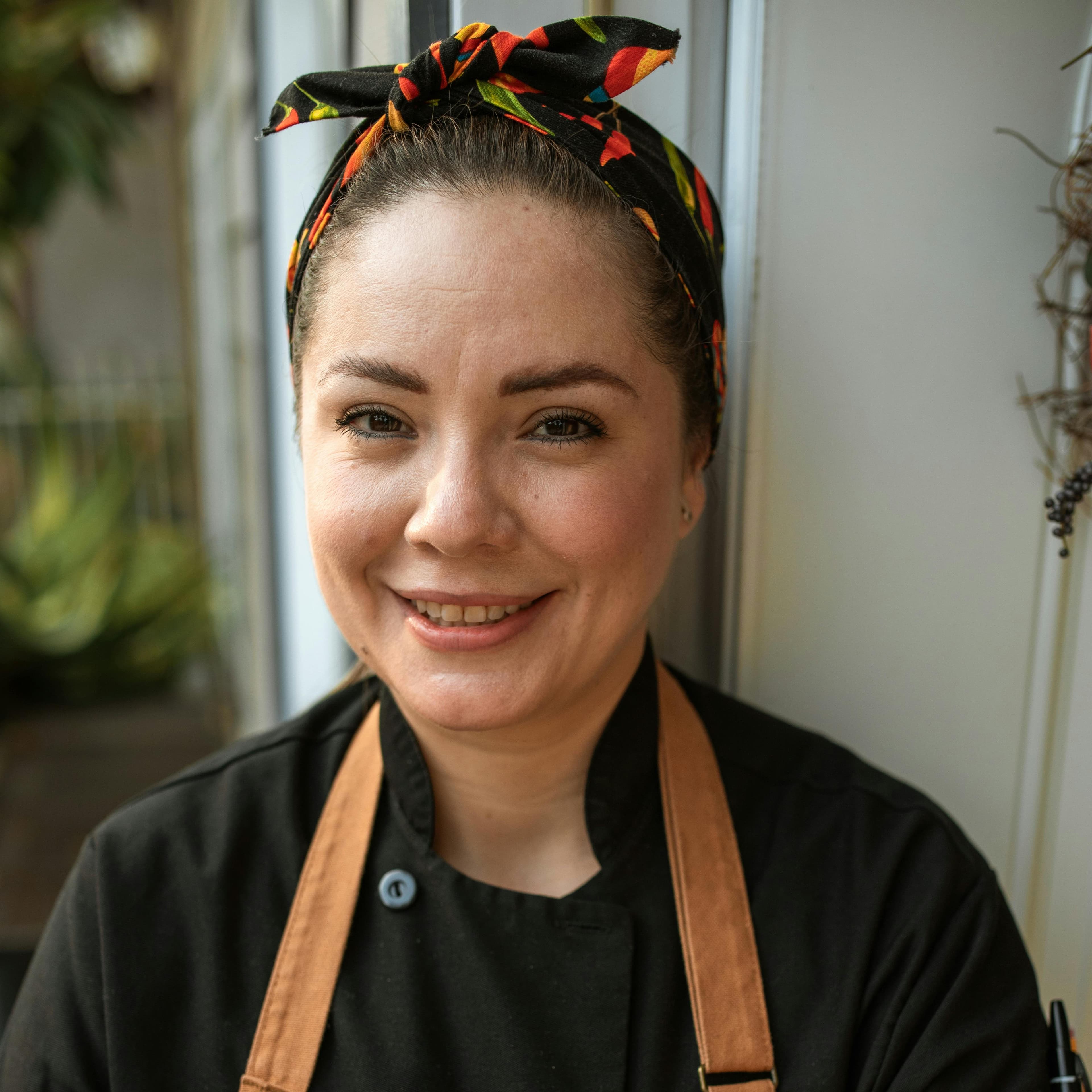 Chef Maria Rodriguez in the kitchen preparing seasonal dishes